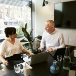 man and woman behind laptop having a meeting